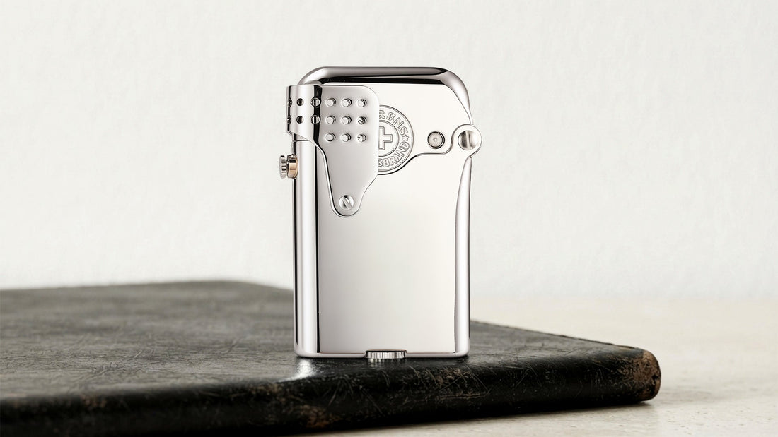 Silver metal lighter with a curved side mechanism on a dark tabletop