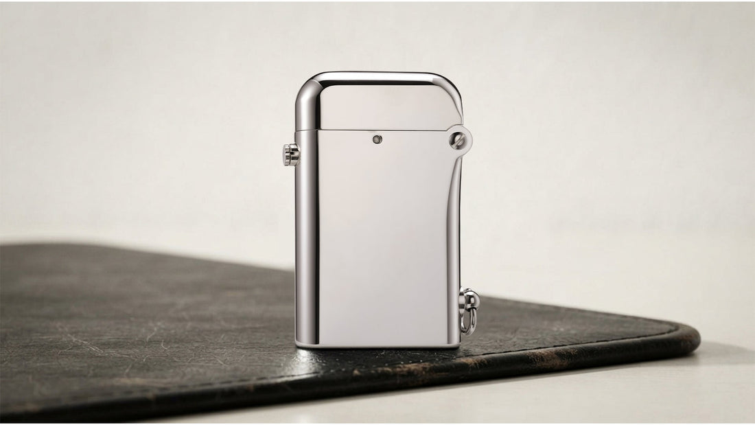 Closed polished silver lighter with side lever on a dark tabletop
