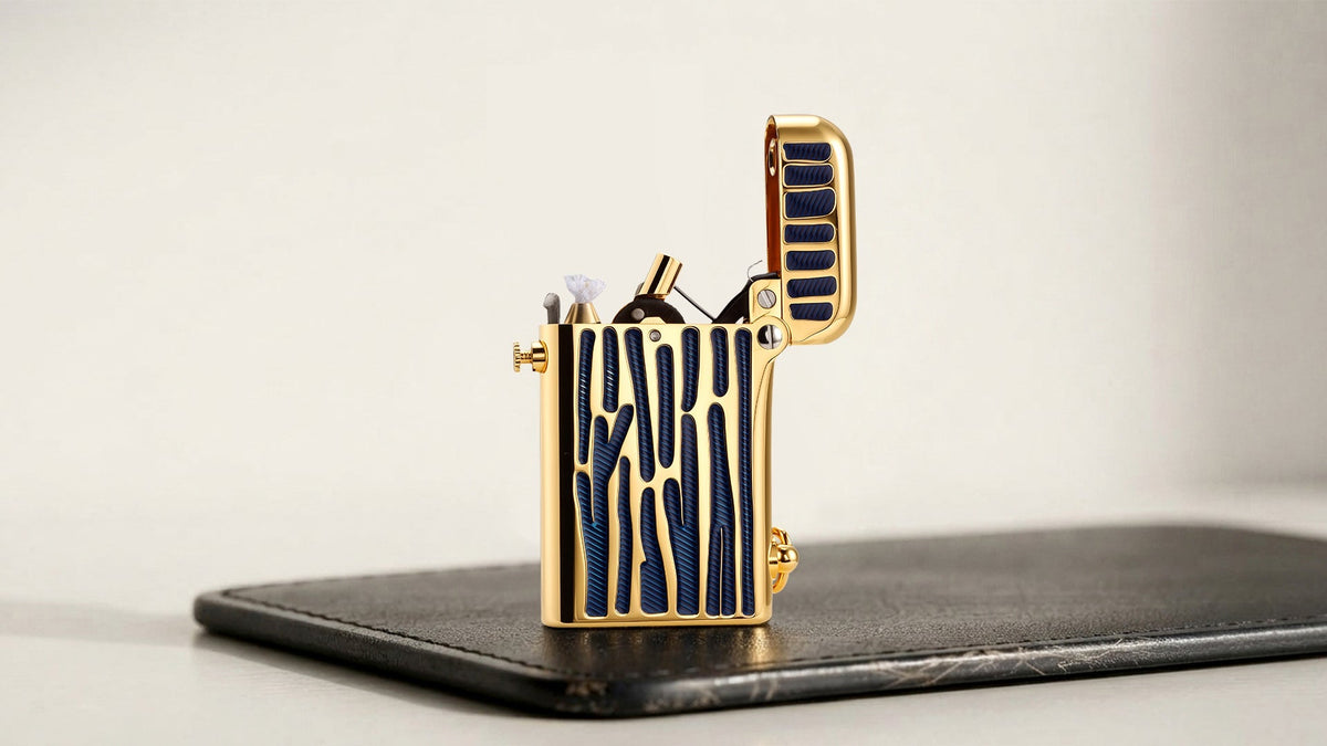 Open gold and blue patterned mechanical lighter on a dark tabletop