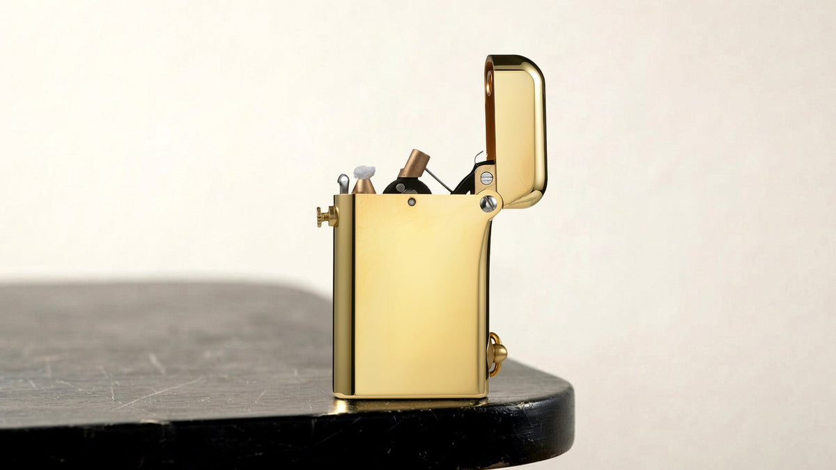 Open gold mechanical lighter displayed on a dark tabletop
