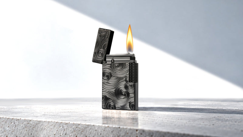 Lit silver lighter with engraved front and open lid