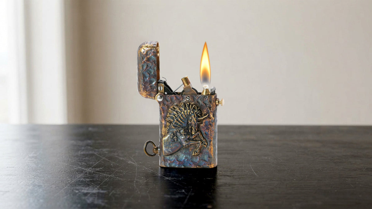 Lit weathered metal lighter with engraved case