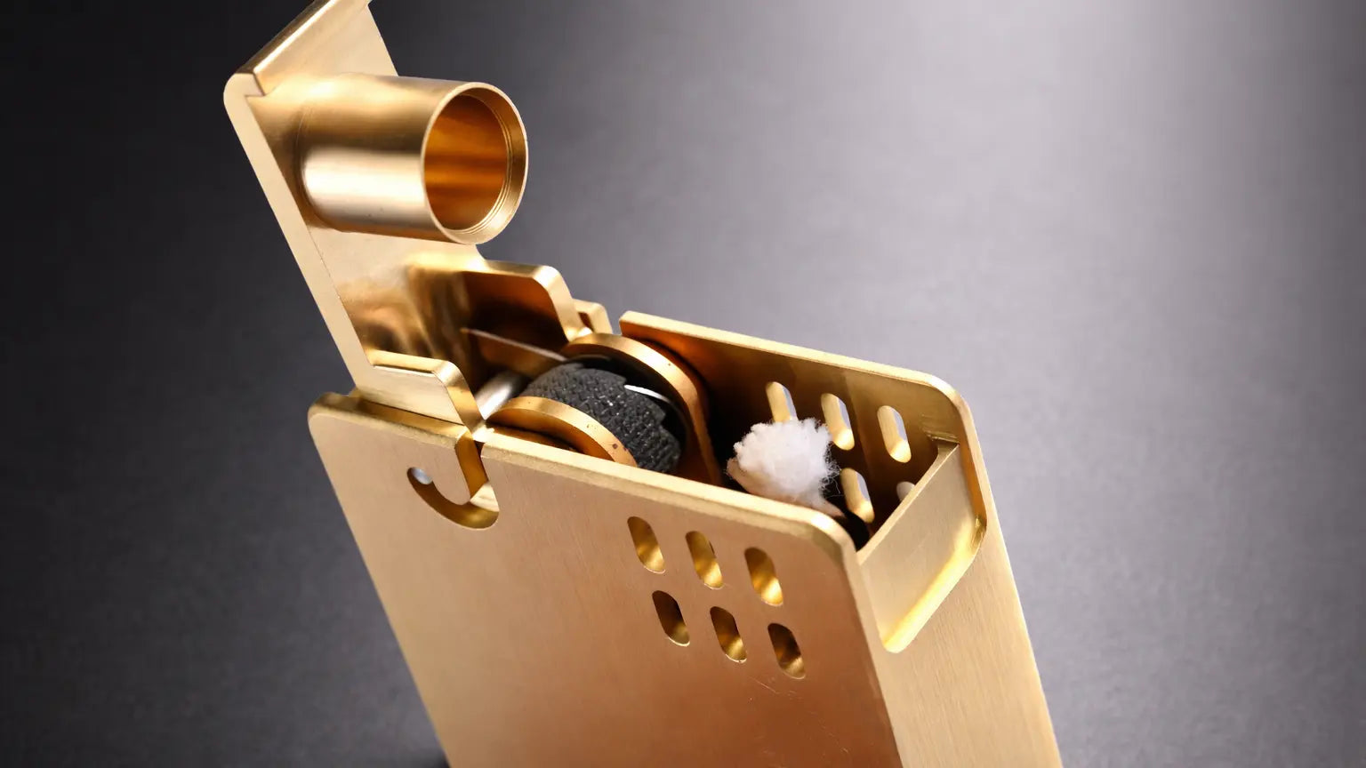 Brushed brass minimalist fluid lighter with side-mounted ignition wheel, shown open for everyday carry use