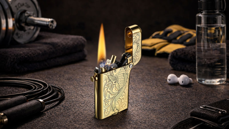THORENS engraved mechanical lighter lit on a gym-style surface with dumbbell, jump rope, gloves, water bottle, and earbuds, illustrating a refined gift idea for guys who work out.