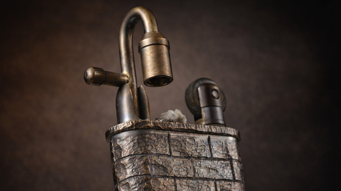 Hand-carved brick wall lighter with textured metal surface, curved lock-style detail, and mechanical fluid ignition design
