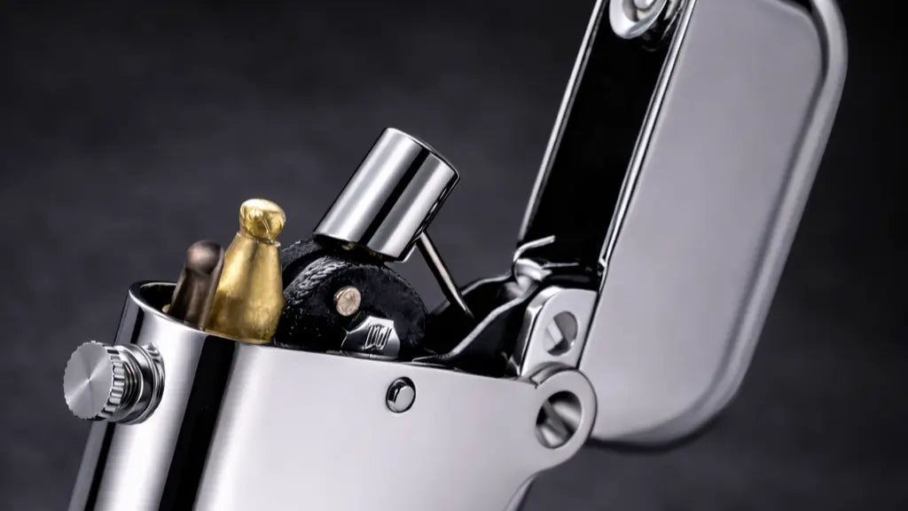 Close-up of a double claw fluid lighter showing the mechanical ignition and refillable brass construction