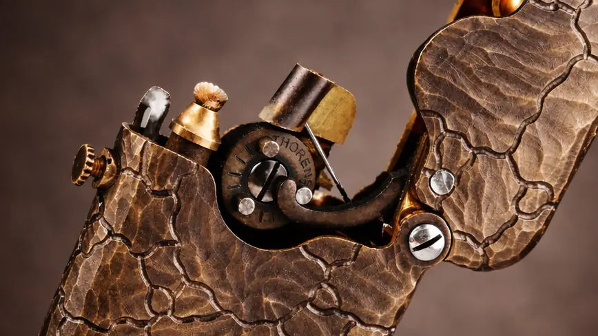 Hand-carved brass mechanical lighter with earth fissure texture and exposed single-claw ignition mechanism