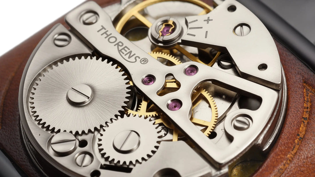Close-up view of a handmade cowhide lighter featuring a decorative mechanical dial with visible gears and engraved THORENS branding
