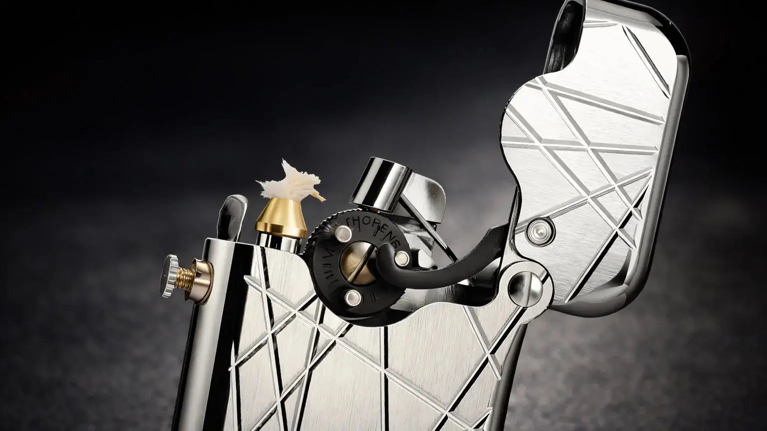 Engraved brass fluid lighter showing the New Gen 3 single-claw mechanical design