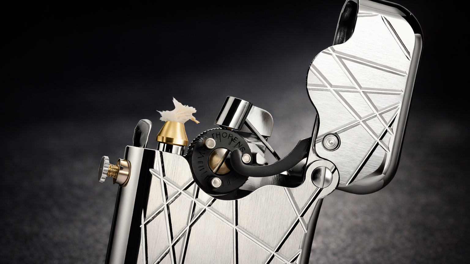 Engraved brass fluid lighter showing the New Gen 3 single-claw mechanical design