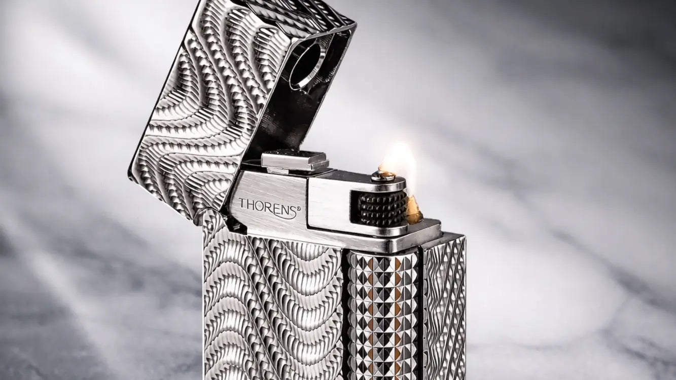 alt="Close-up detail of the Side Slip Narrow lighter Argent Mirage, featuring engraved silver metal body and side-slide ignition"