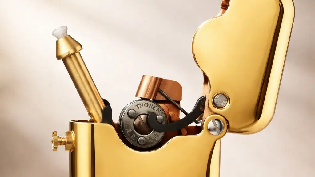 Close-up view of a single-claw TELEFLAM brass fluid lighter showing exposed mechanical ignition details