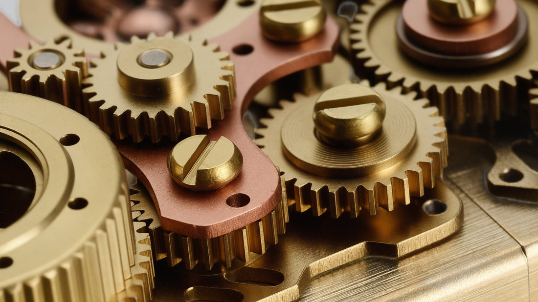 Close-up of exposed brass gears on a steampunk mechanical lighter, showing detailed gear linkage and industrial design