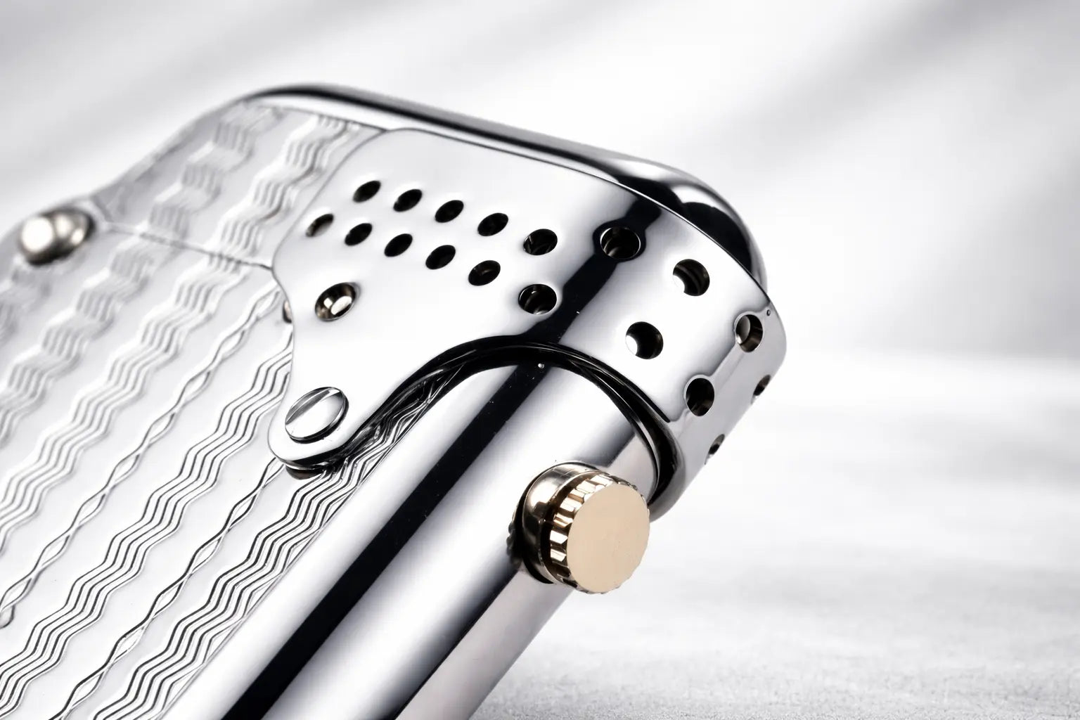 Close-up detail of a Storm Wave double claw lighter with engraved wave surface and windproof shield