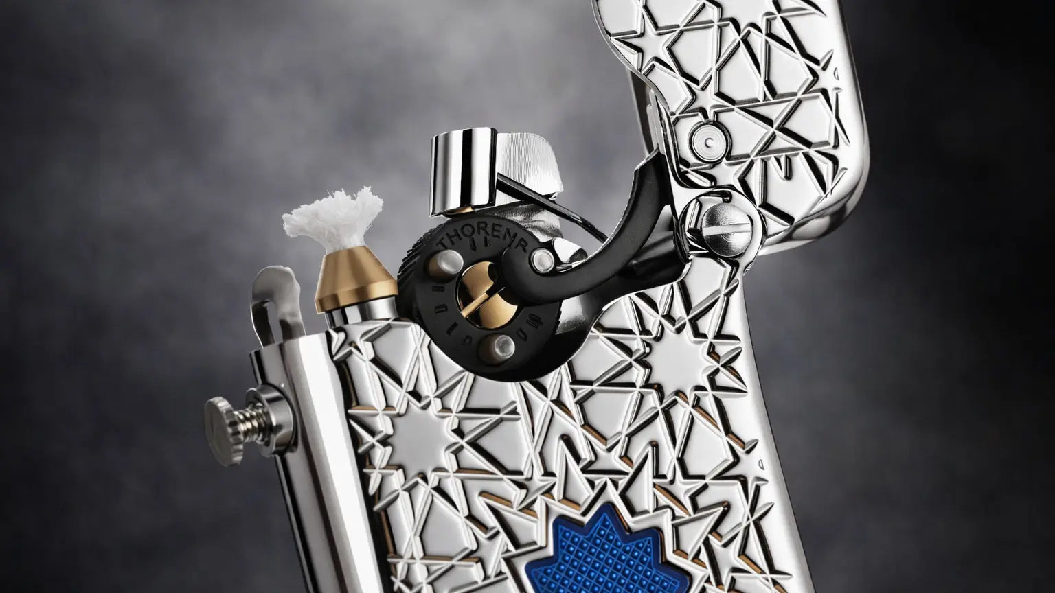 Close-up of the THORENS Blue Lucky Star Single Claw mechanical fluid lighter showing the engraved brass body and ignition mechanism
