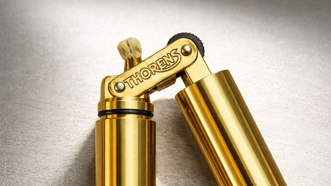 Close-up of the THORENS Nunchaku fluid lighter in gold, showing the articulated hinge and engraved branding.