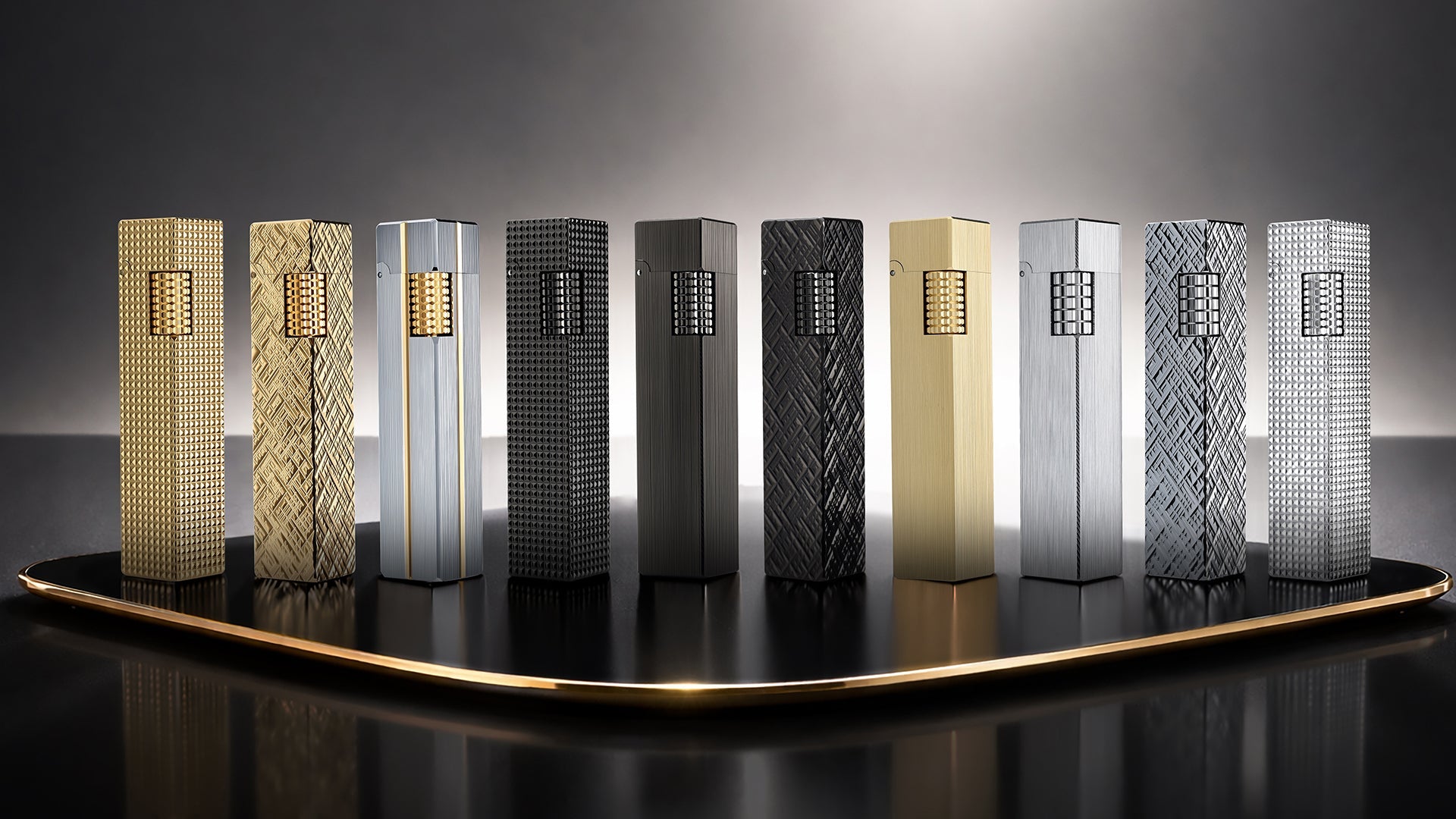 Lineup of THORENS Rectangular Series fluid lighters displayed on a dark presentation platform, featuring rectangular designs in gold-tone, silver-tone, and black metal finishes with different engraved textures.