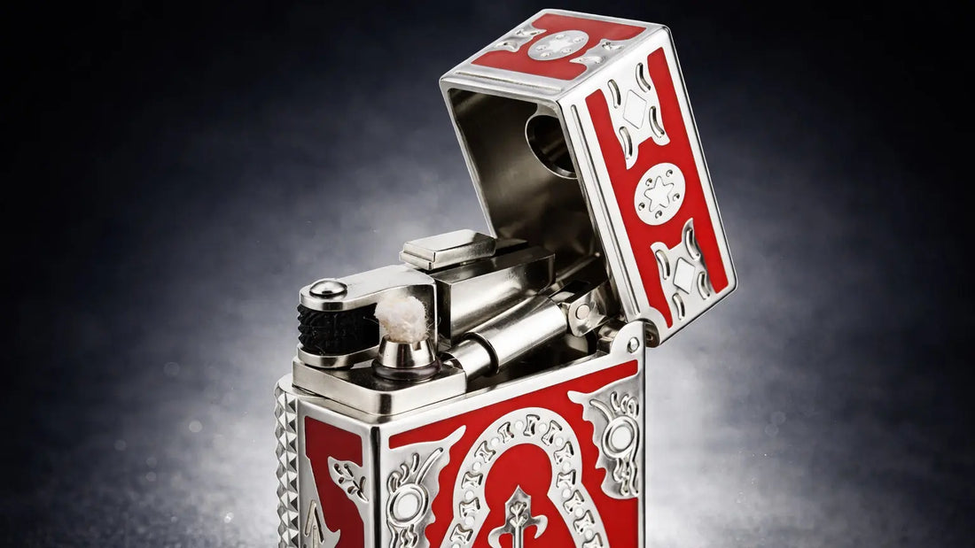 Side slip lighter with polished silver body and red enamel panels, featuring a Holy Grail emblem and exposed mechanical ignition with cotton wick