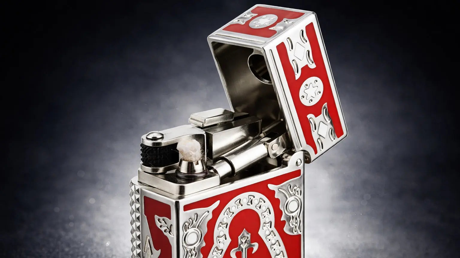 Side slip lighter with polished silver body and red enamel panels, featuring a Holy Grail emblem and exposed mechanical ignition with cotton wick