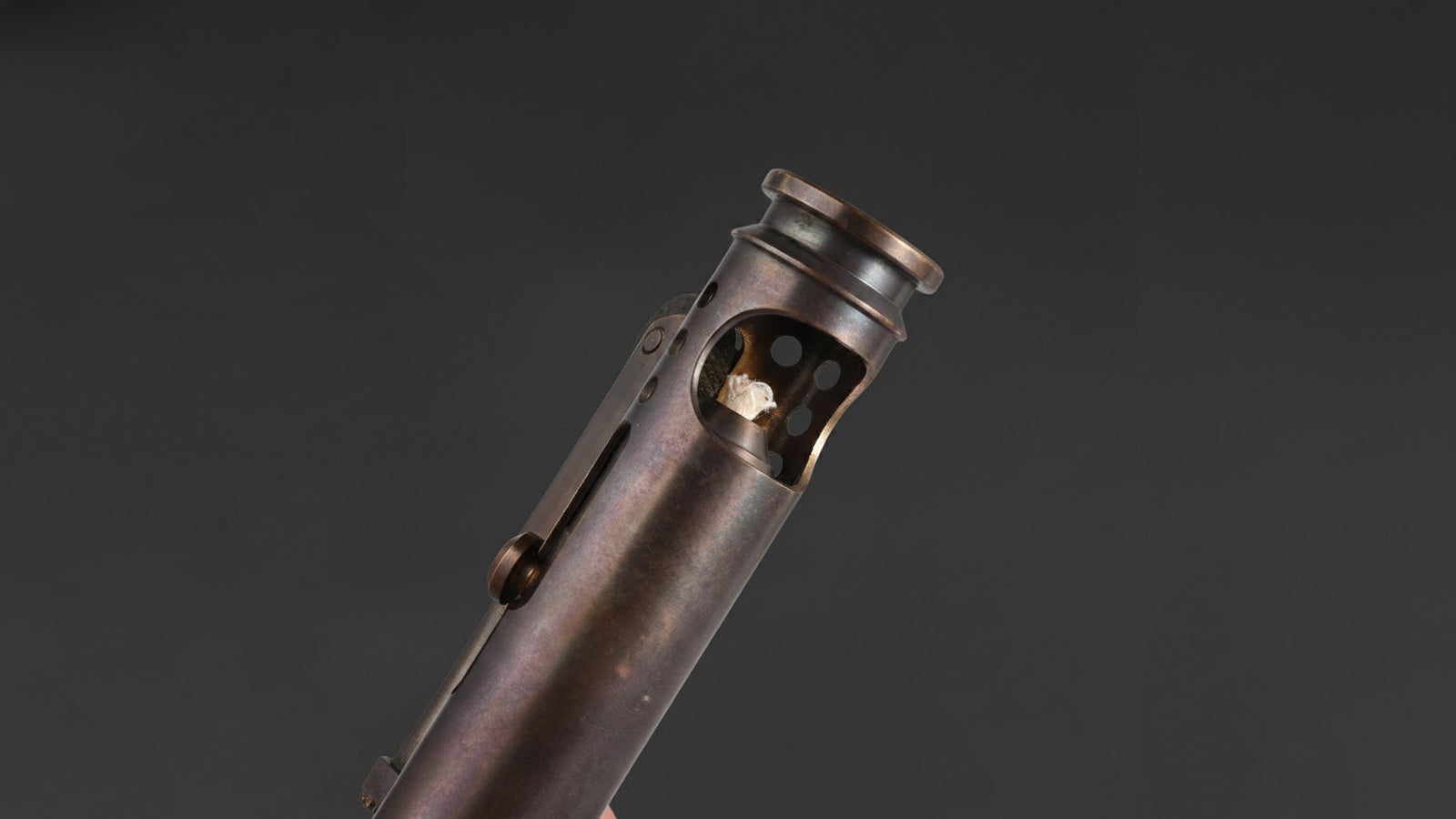 Antique brass trench lighter showing compact mechanical design and exposed wick structure