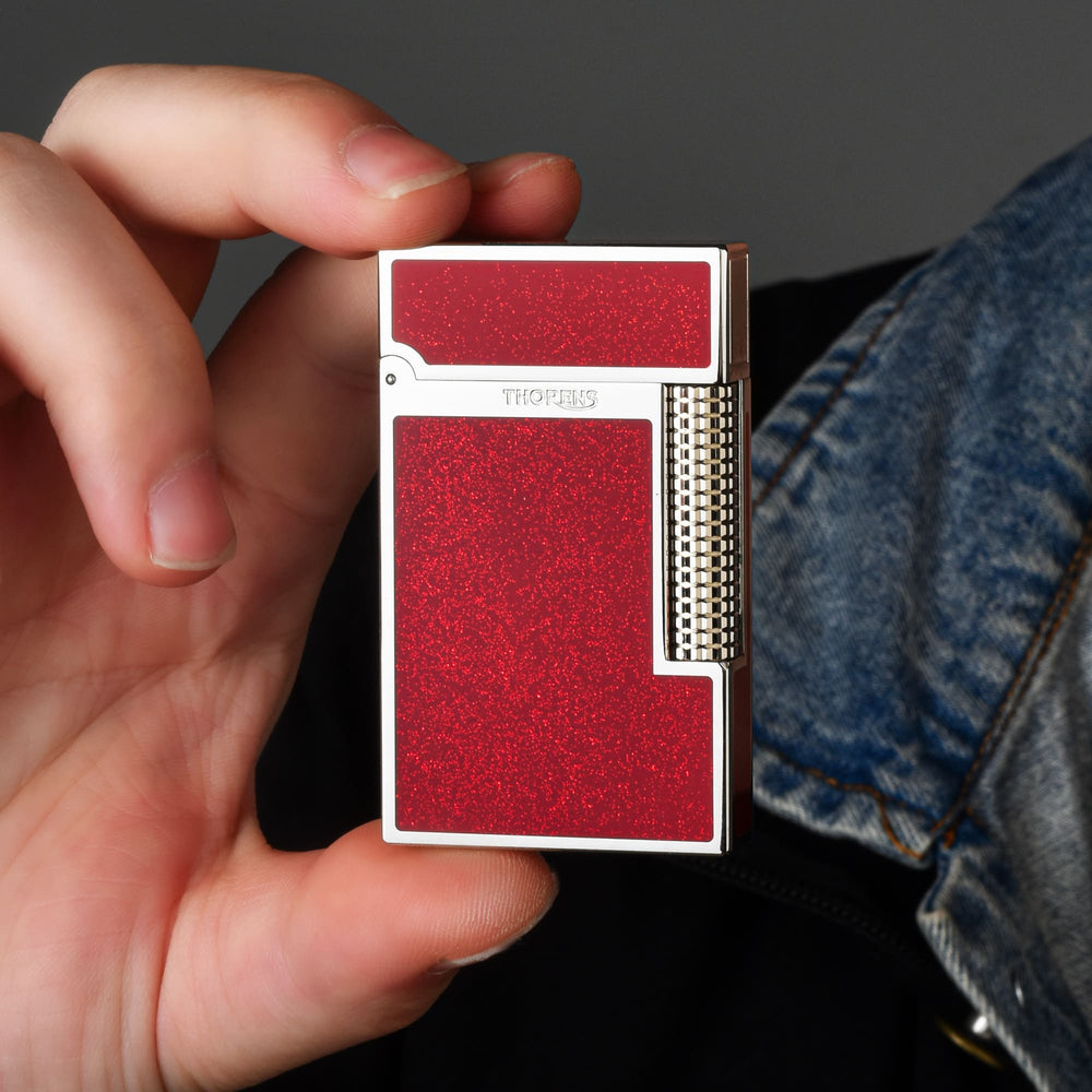 Thorens Scarlet Stardust mechanical fluid lighter featuring a shimmering red finish, polished chrome frame, and precision-engineered roller.