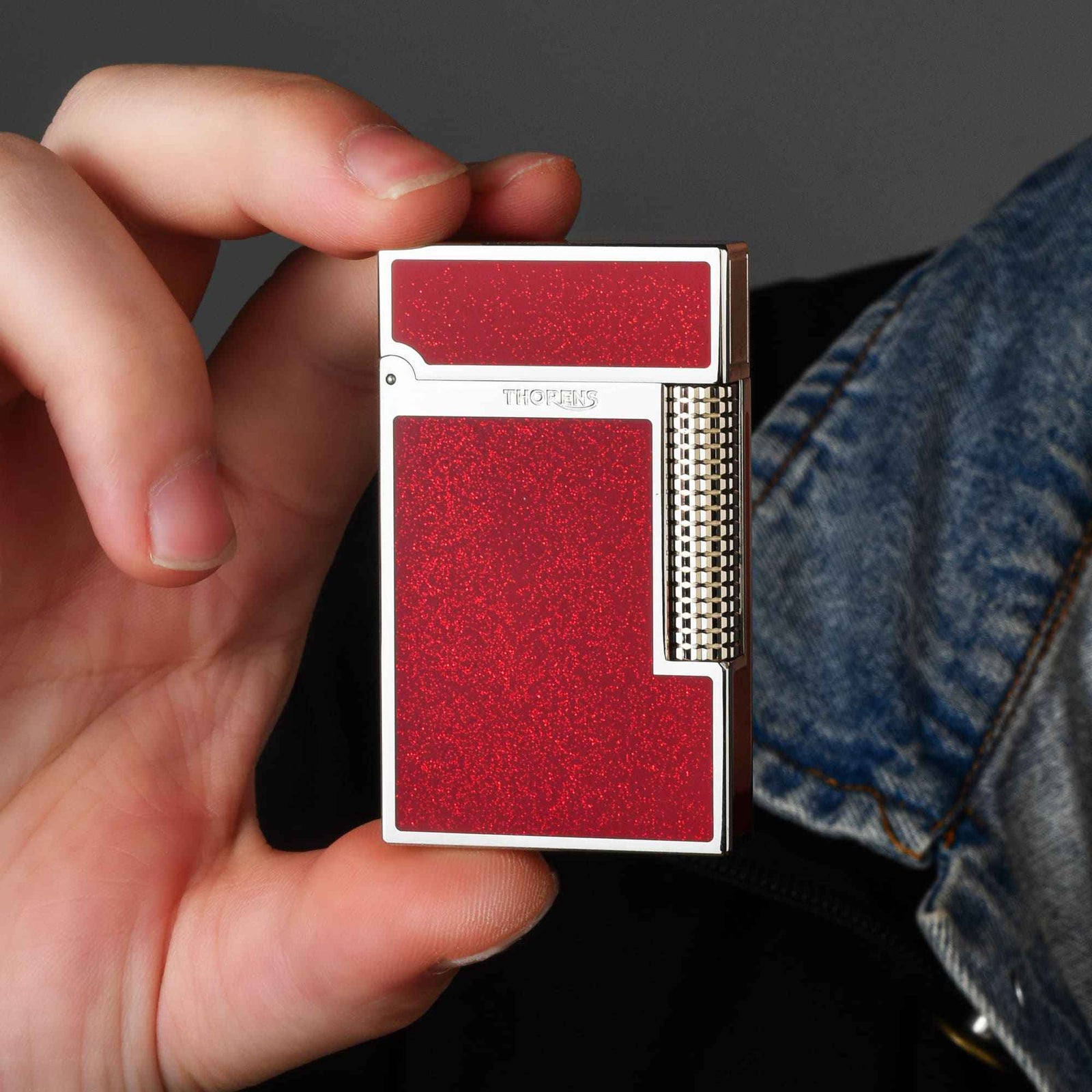 Thorens Scarlet Stardust mechanical fluid lighter featuring a shimmering red finish, polished chrome frame, and precision-engineered roller.