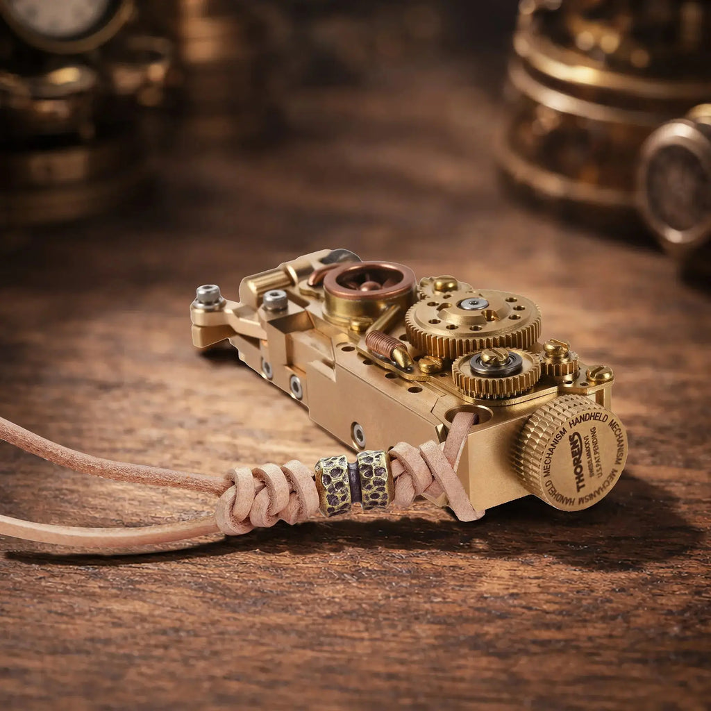 Thorens steampunk mechanical grip grand gear lighter in brass finish resting horizontally on a warm wood surface, featuring oversized exposed gear detailing, layered brass construction, and a leather lanyard with bead accents