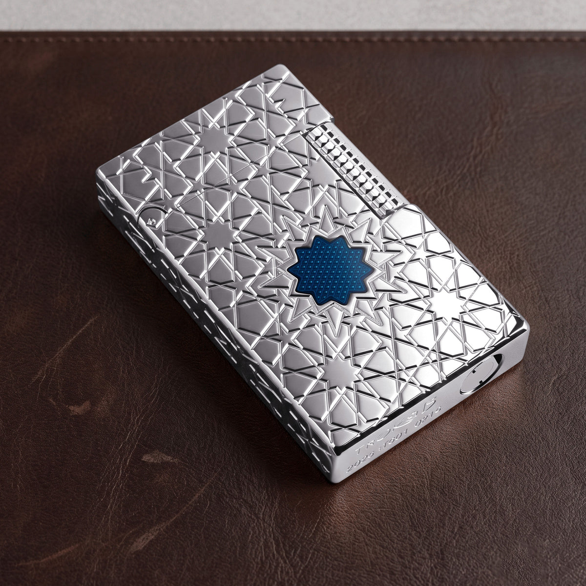 Thorens Stellar Mesh Silver 라이터의 상세 모습. 정밀하게 커팅된 부싯돌 휠, 하단 각인, 실버 바디와 대비되는 선명한 블루 메쉬 스타 인레이를 확인할 수 있습니다.
