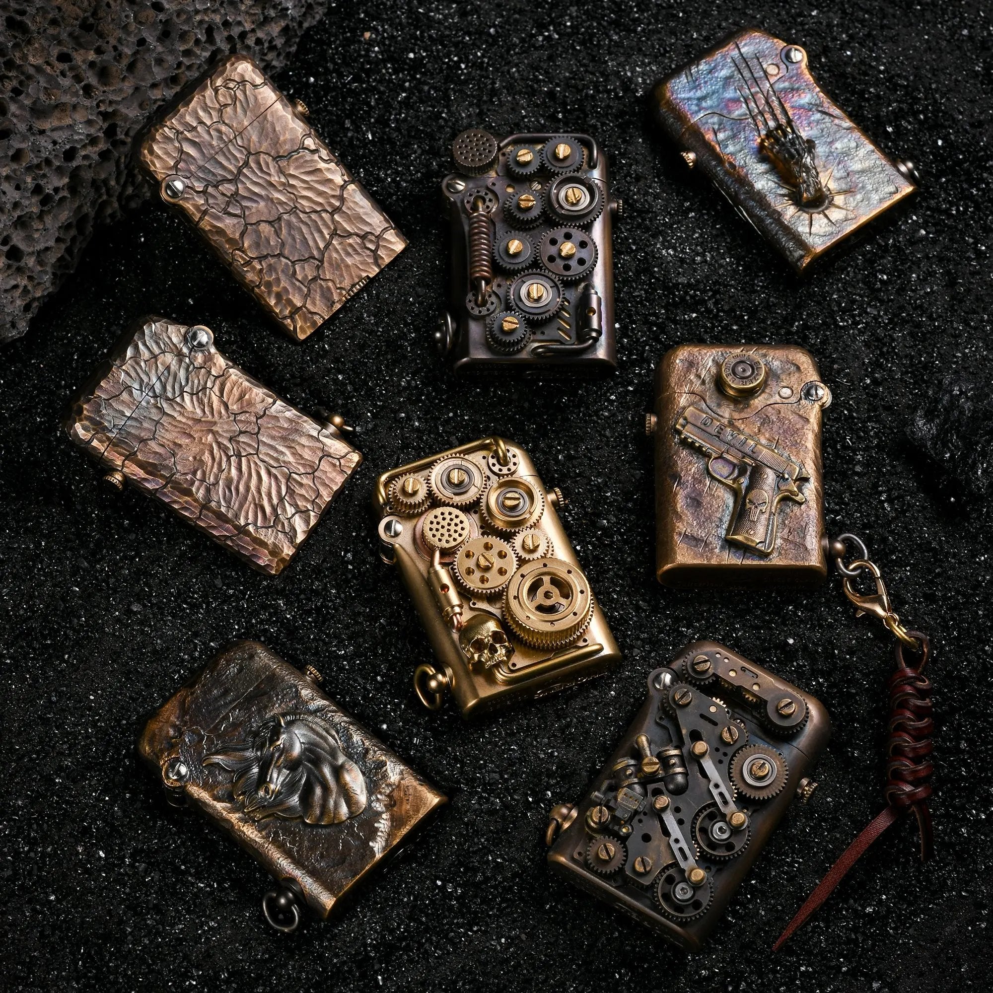A group of Gen 1 Single Claw Spirit Claw lighters featuring intricate steampunk gears, hand-carved textures, and brass reliefs on a black volcanic sand background.