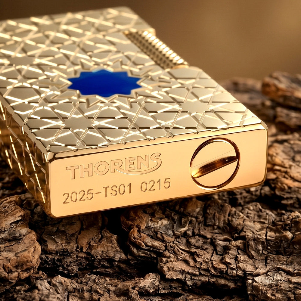 Close-up product details of the Stellar Mesh Gold lighter showcasing the textured flint wheel, deep-etched geometric star patterns, and signature blue mesh inlay.