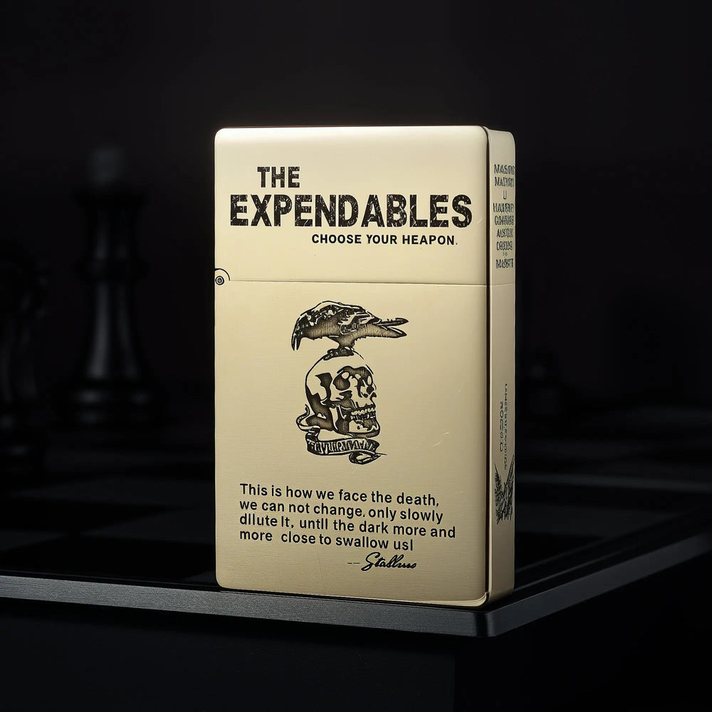 Upright Thorens brass lighter featuring THE EXPENDABLES movie logo, skull imagery, and iconic quote etching on a matte gold-tone surface.