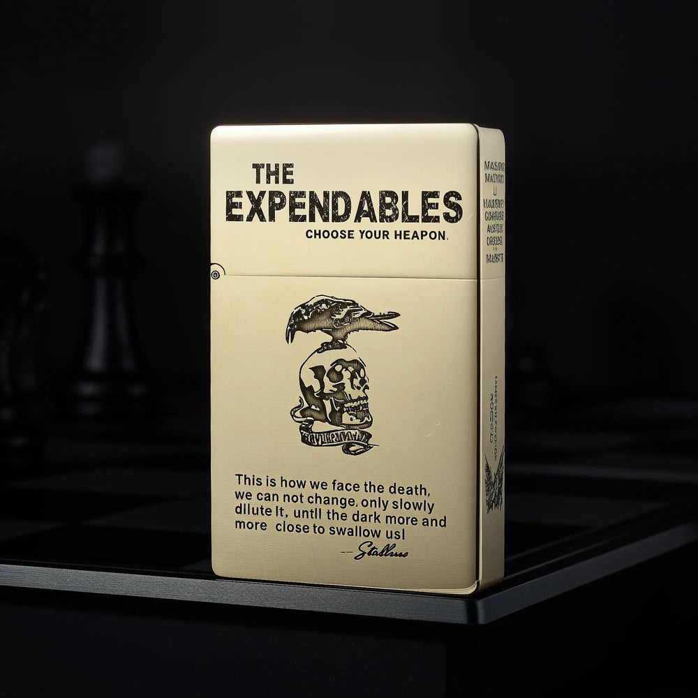 Upright Thorens brass lighter featuring THE EXPENDABLES movie logo, skull imagery, and iconic quote etching on a matte gold-tone surface.