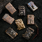 A curated selection of Gen 1 Single Claw lighters, including the hand-carved Earth Fissure models, steampunk gear designs, and relief sculptures, displayed on black volcanic sand.