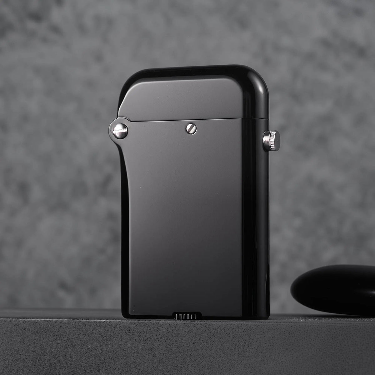 The back profile of a Gen 4 Double Claw lighter showing the smooth glossy black finish and precision screw hinge on a granite-style background.
