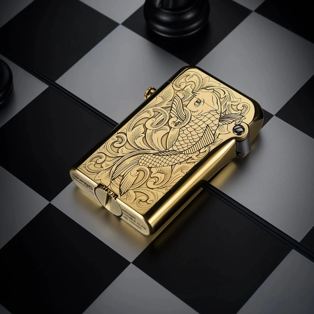 A brass Thorens Gen 4 double claw lighter resting on a chessboard, showcasing the detailed koi fish engraving and mechanical base markings.