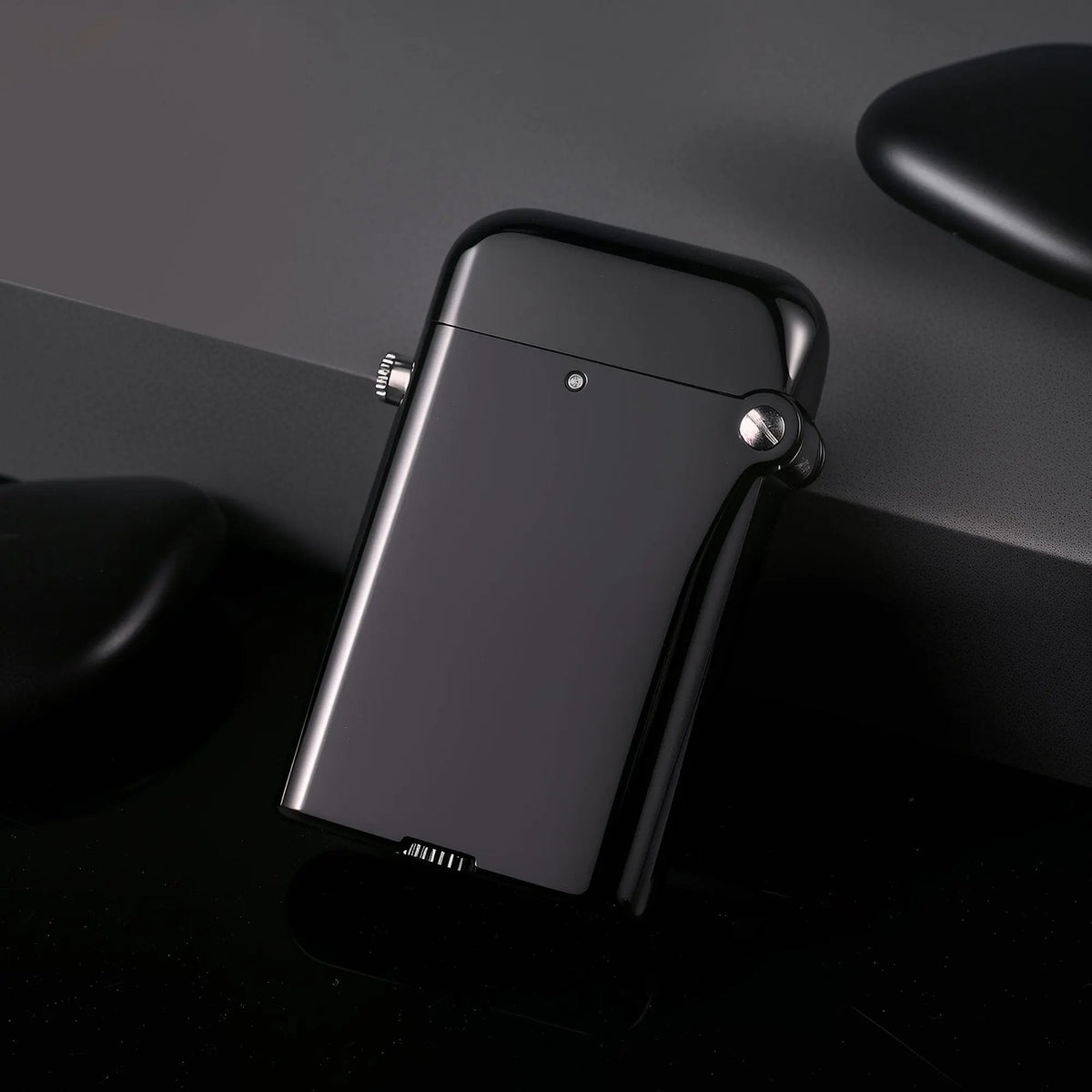 A Gen 4 Double Claw lighter resting at an angle, showcasing its glossy black finish and bottom fill wheel against a minimalist dark backdrop.