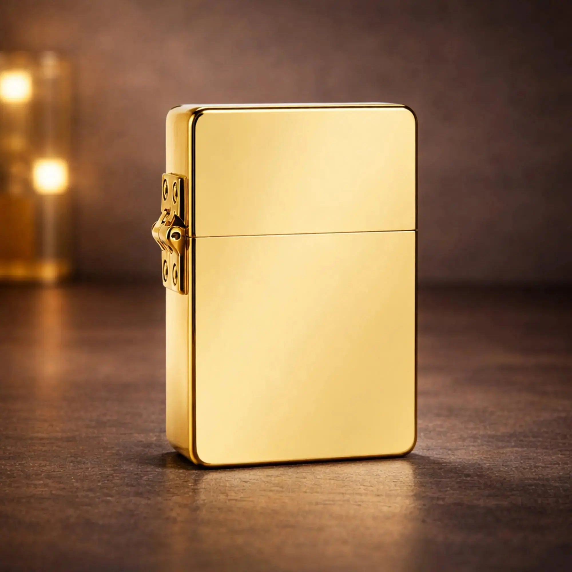 A luxurious shot of a gold-finish Armor lighter standing on a dark, textured surface. The warm, moody lighting accentuates its mirror-like high-polish finish and the prominent, heavy-duty external hinge that defines the Armor series.