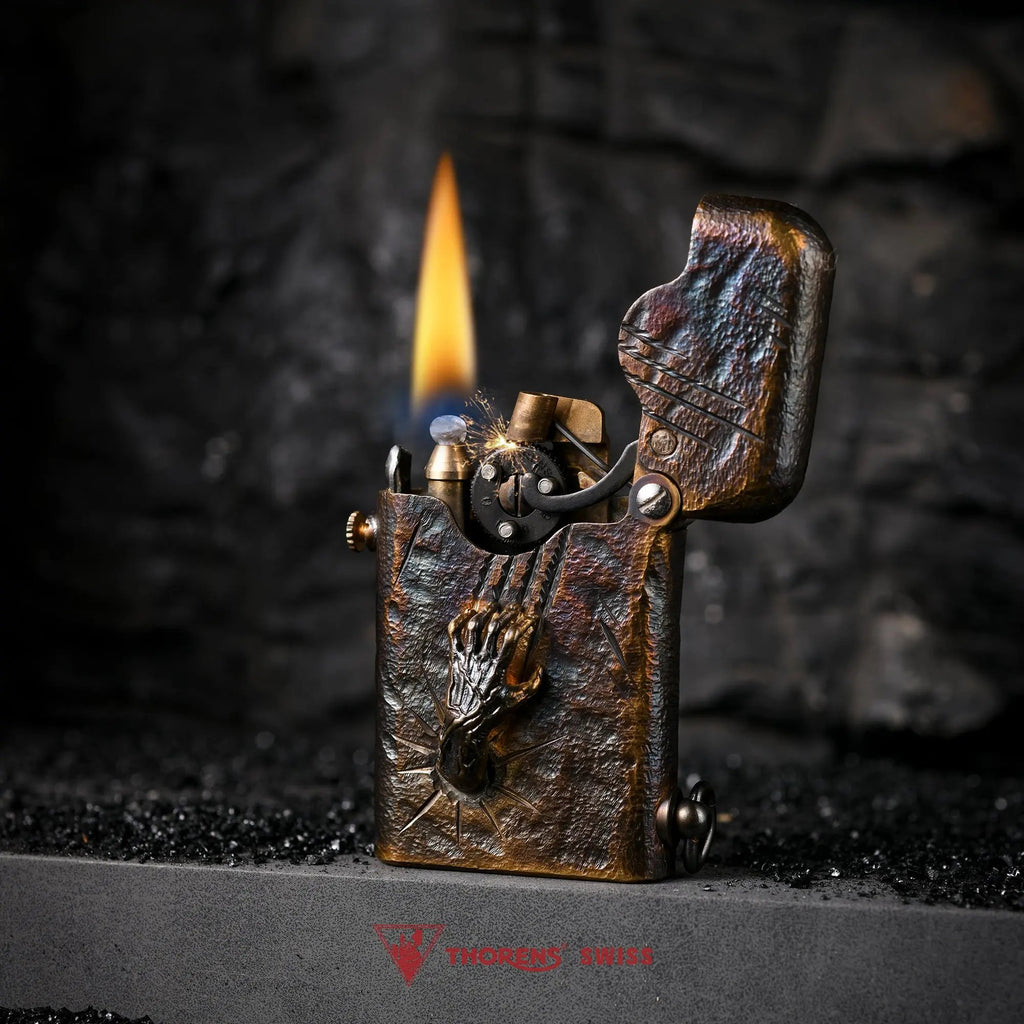 An ignited Gen 1 Single Claw Spirit Claw lighter, showing the mechanical gear spark and flame alongside its rugged hand-carved skeletal relief.