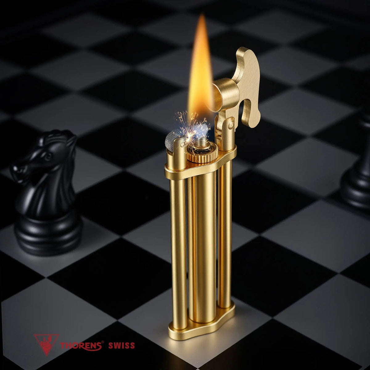 An ignited Three-Section Stick Lighter in brushed brass, demonstrating the mechanical flint ignition and vertical flame on a black-and-white chessboard.