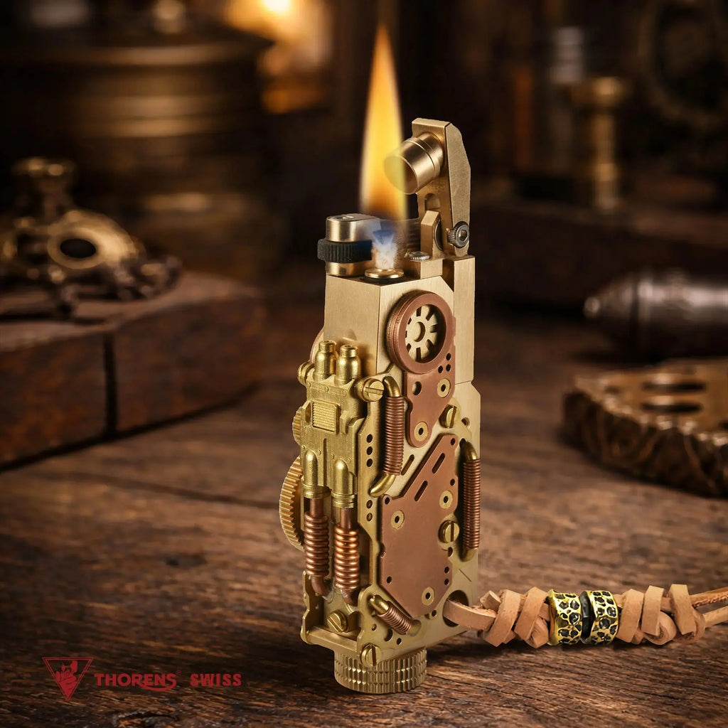 Thorens steampunk mechanical grip grand gear lighter in brass finish shown lit on a warm wood surface, featuring oversized mechanical detailing, layered brass construction, and a leather lanyard with bead accents