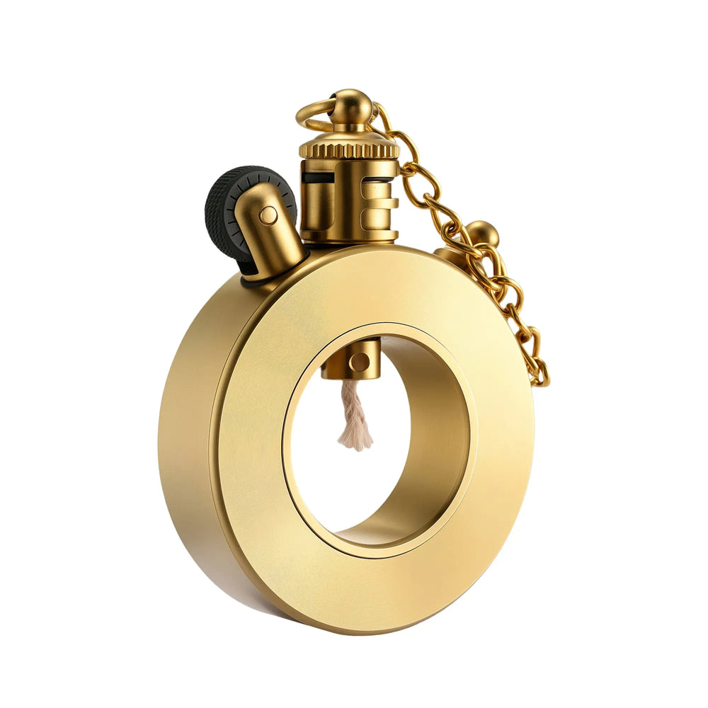 A Seahorse Trench lighter featuring a unique hollow circular frame, brushed brass finish, integrated wick, and a mechanical flint wheel with a safety chain.