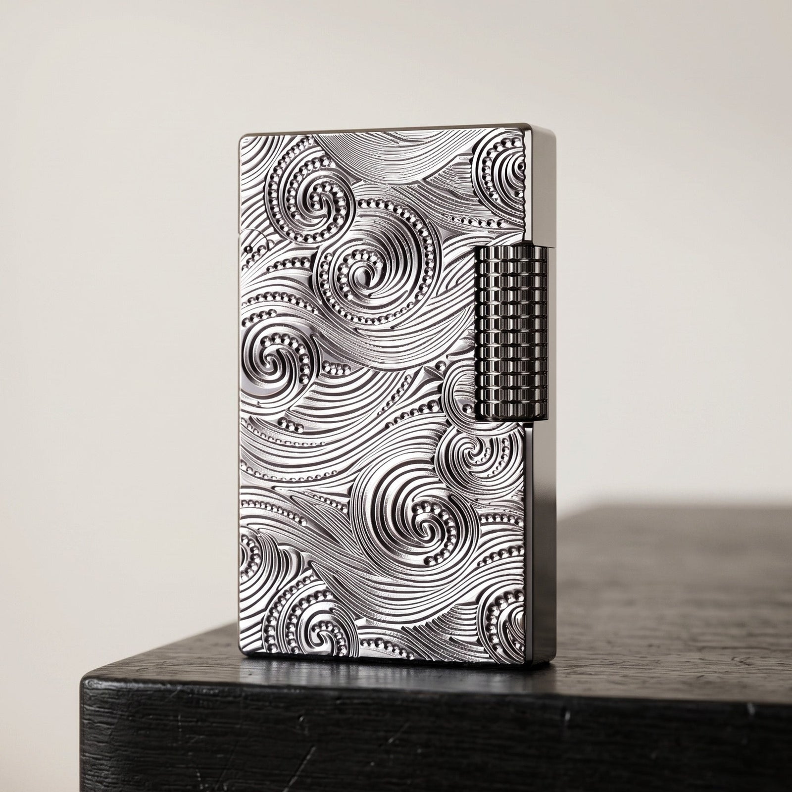 A cinematic shot of an open "Side Slip" lighter in a brilliant silver finish, featuring deep-carved vortex and swirl engravings. The image highlights the polished brass wick holder, the textured side-slip roller, and the high-luster interior of the flip-top lid.