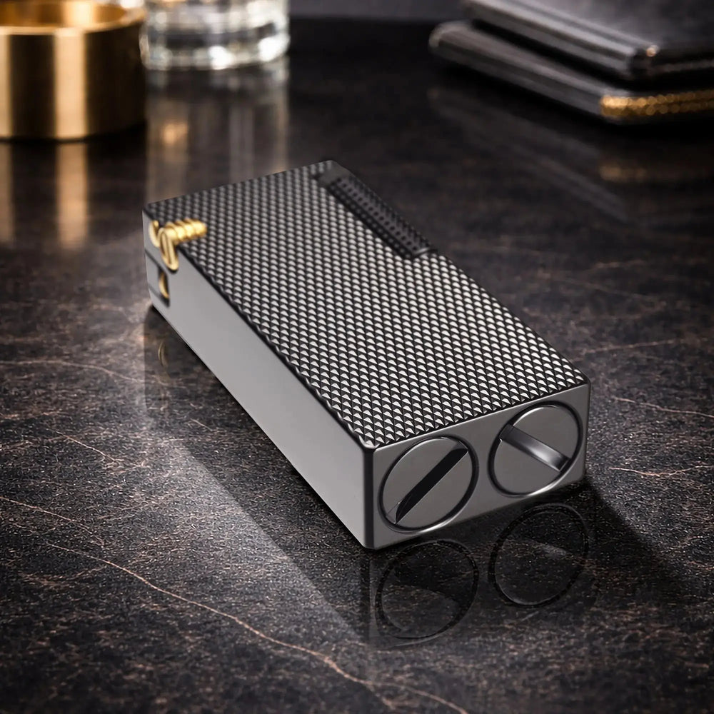 Thorens Slim Cube Black Mesh lighter resting on a reflective dark surface, featuring a slim rectangular form, black mesh texture, dark-toned body, and gold-tone accent detail