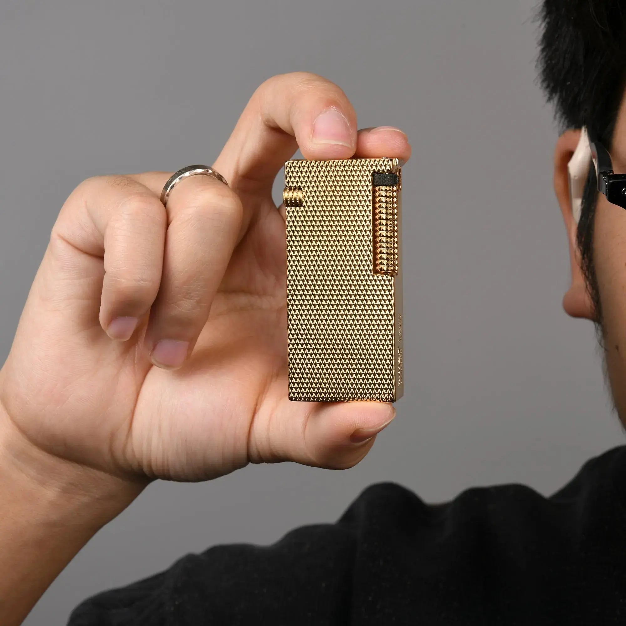 Thorens Slim Cube Golden Mesh lighter held in hand, showing its slim rectangular form, golden mesh finish, polished gold-tone edges, and refined mechanical detailing against a neutral background