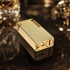 Thorens Slim Cube Golden Mesh lighter resting on a reflective dark surface, featuring a slim rectangular form, golden mesh texture, polished gold-tone body, and refined mechanical detailing