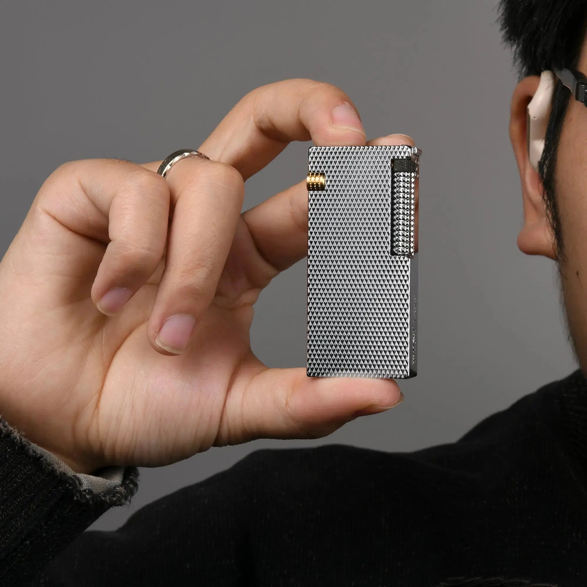 Thorens Slim Cube Silver Mesh lighter held in hand, showing its slim rectangular form, silver mesh finish, polished silver-tone edges, and gold-tone accent against a neutral background