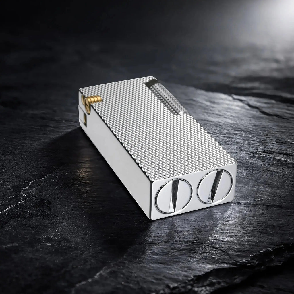 Thorens Slim Cube Silver Mesh lighter resting on a dark textured surface, featuring a refined rectangular form, silver mesh pattern, polished silver-tone body, and gold-tone accent detail