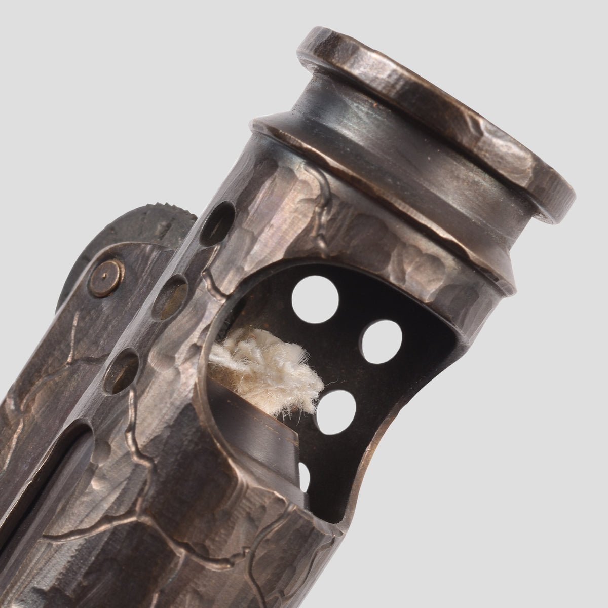 A vertical shot of the Battle Soul trench lighter standing upright, featuring hand-carved cracks on a weathered brass body with a sliding windguard.