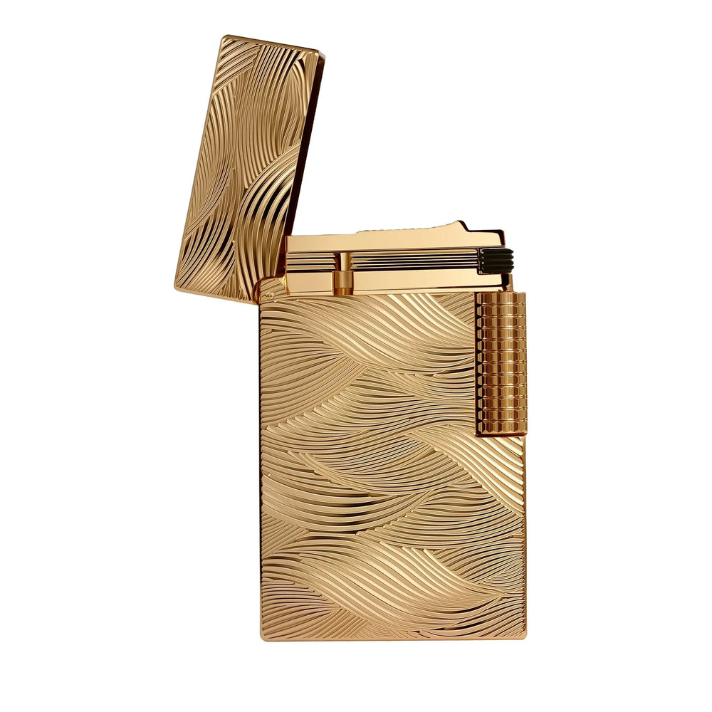 Thorens Aqua Rhythm gold lighter with an open cap, showcasing the brass body and intricate wave-like engravings with a mechanical side roller.