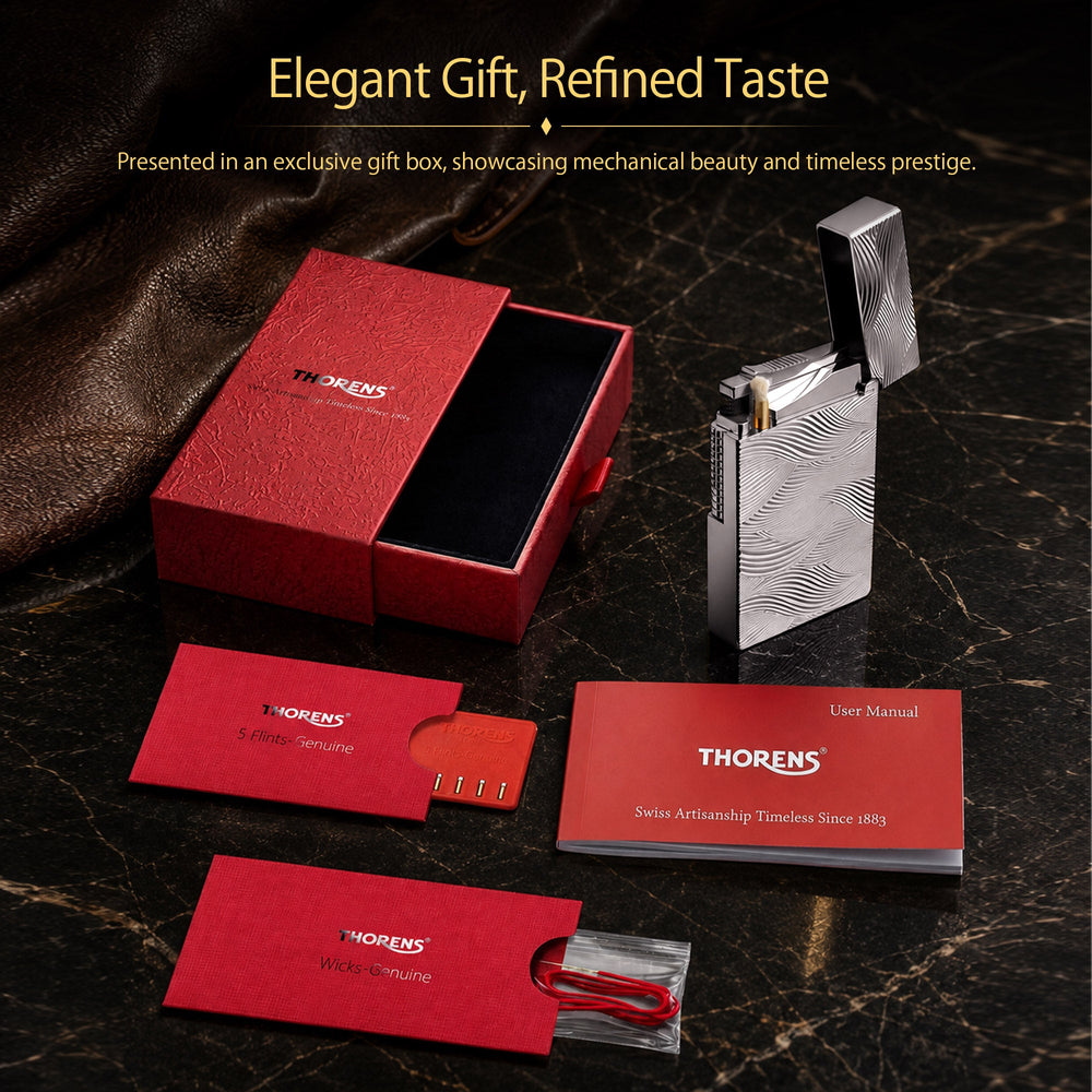 A breakdown of the Thorens Aqua Rhythm silver lighter set, including the red presentation box, genuine wicks, genuine flints, and the user manual.